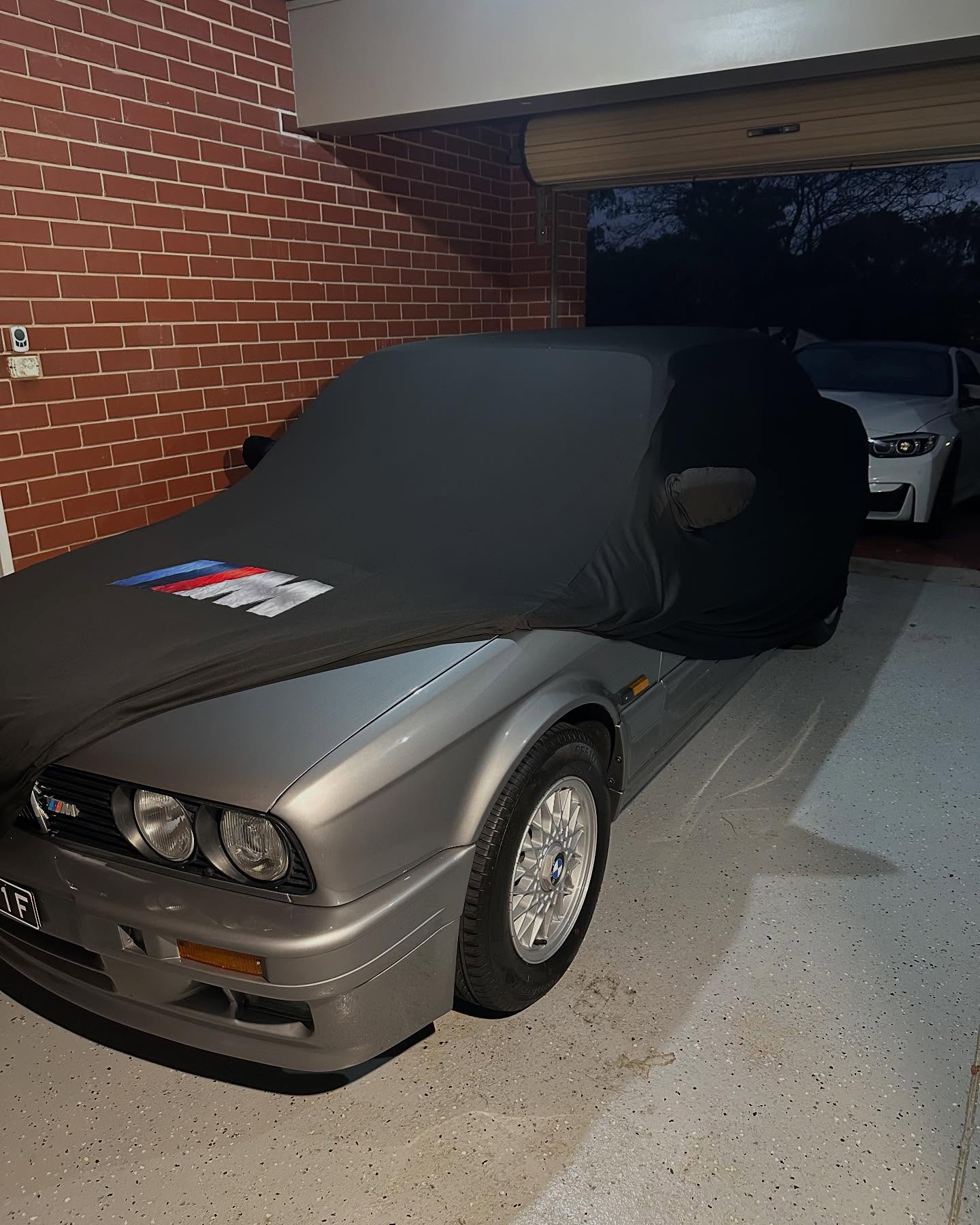 Black cover with BMW M stripes on an E30