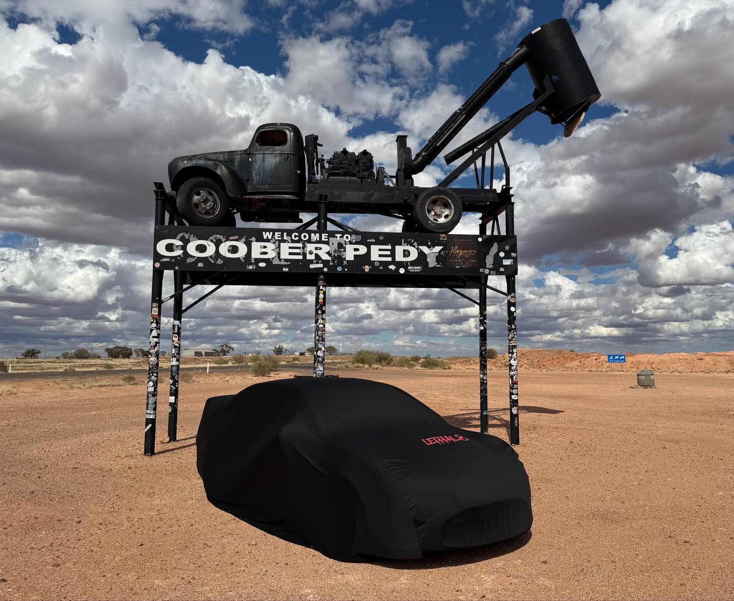 Black cover on a car at the Coober Pedy sign