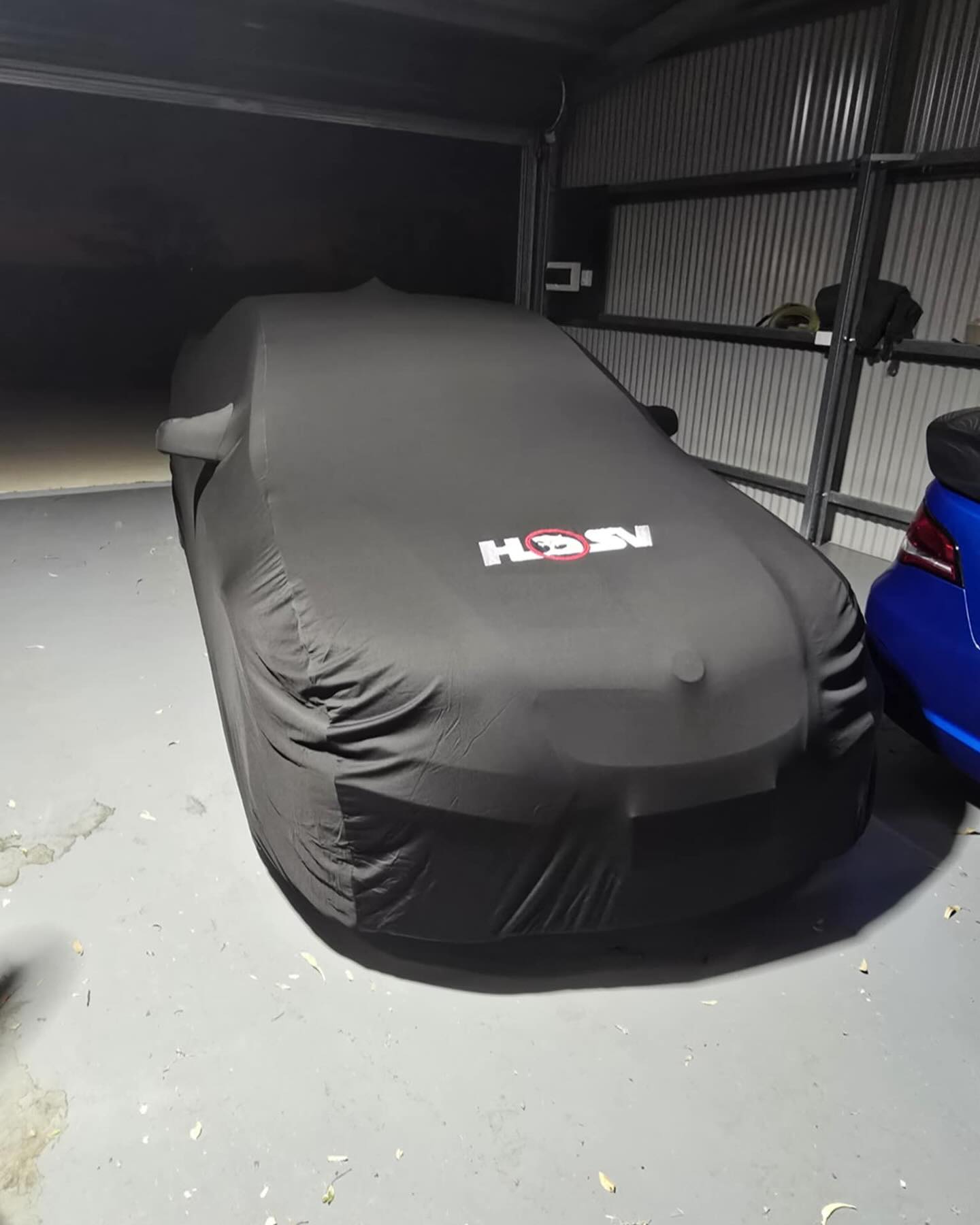Black HSV cover in a shed at night